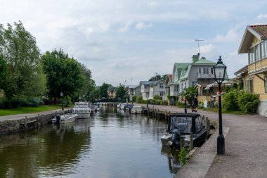 Trosa, İsveç - 22 Haziran 2021: Pek çok tekne İsveç 'in huzurlu Trosa köyündeki liman kanalı boyunca kuyruk oluşturur.