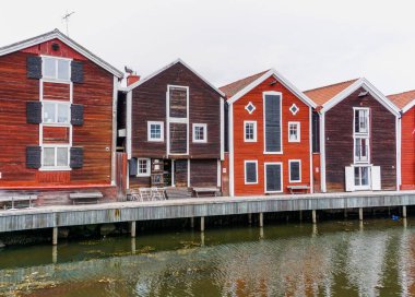 Hudiksvall, İsveç - 7 Temmuz 2021: Hudiksvall rıhtımı boyunca kırmızı ve kahverengi ahşap depolar