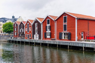 Hudiksvall, İsveç - 7 Temmuz 2021: Hudiksvall rıhtımı boyunca kırmızı ve kahverengi ahşap depolar