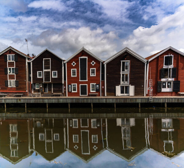 Hudiksvall, Sweden - 7 July, 2021: red and brown wooden warehouses along the waterfront in Hudiksvall