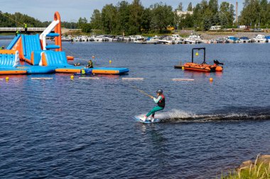 Oulu, Finlandiya - 25 Temmuz 2021: Wakeboard güzel bir yaz gününde Oulu şehir merkezindeki Wakepark 'ta eğleniyor.