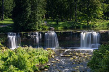 Ormanda şelalesi olan cennet gibi bir nehir manzarası.