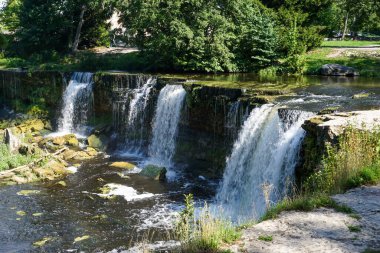 Ormanda şelalesi olan cennet gibi bir nehir manzarası.