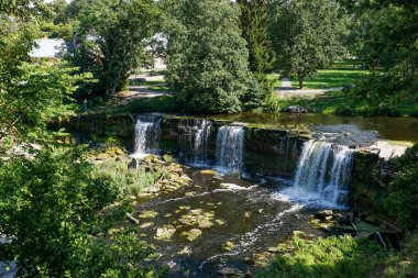 Ormanda şelalesi olan cennet gibi bir nehir manzarası.