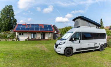 Kuressaare, Estonya - 13 Ağustos 2021: arkasında güneş panelleri olan bir sağlık tesisleri olan gri bir karavan.