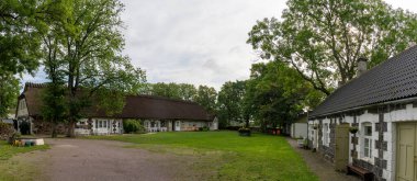 Koguva, Estonya - 16 Ağustos 2021: Estonya kırsalındaki tarihi taş çiftlik binaları ve kulübeleri