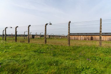 Auschwitz, Polonya - 15 Eylül 2021: Auschwitz toplama kampındaki esir kışlalarını dikenli tellerle çevreleyen çitler