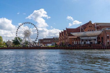 Danzig, Polonya - 2 Eylül 2021: Dönme dolap ve tarihi binalar ile Danzing 'in eski kasabasındaki Motlawa Nehri üzerinde şehir tabelası