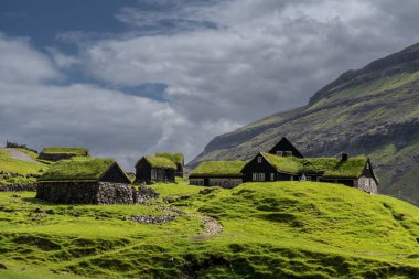 Saksun, Faroe Adaları - 7 Temmuz 2025: Faroe adasının Streymoy adasındaki Saksun 'daki Duvugardar açık hava müzesindeki tarihi çimenli çiftlik evlerinin manzarası