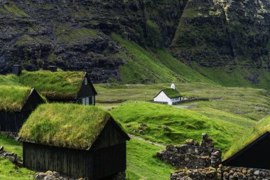 Saksun, Faroe Adaları - 7 Temmuz 2025: Faroe adasındaki Saksun köyündeki tarihi çim çatılı çiftlik evleri ve kilise manzarası