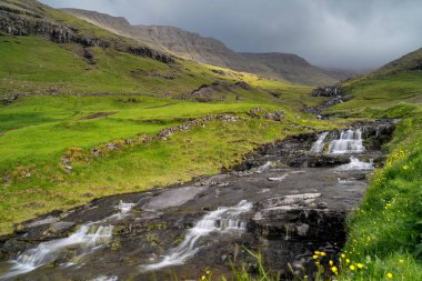 Stora Nehri manzarası ve Faroe Adaları 'ndaki Sorvagsfjord kıyılarında Bour yakınlarındaki şelaleler.