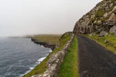 Sisli ve bulutlu bir günde Sanduk 'tan Soltavik' e uzanan tek şeritli dar bir yol.