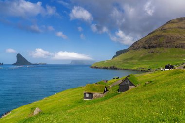 Bour, Faroe Adaları - 7 Temmuz 2025: Faroe Adaları 'ndaki Sorvagsfjord kıyılarında çimen çatılı geleneksel ahşap evler