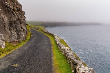 Sisli ve bulutlu bir günde Sanduk 'tan Soltavik' e uzanan tek şeritli dar bir yol.