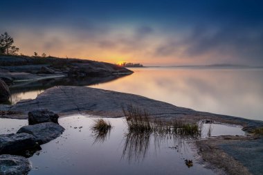 Sıcak ve sisli günbatımı adalar ve skerries ve Vikarfjarden üzerinde Aland Adaları takımadaları yakınlarındaki Sando Adası.