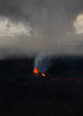 İzlanda 'da Reykjavik' in güneyinde küçük bir volkan patlar ve lav siyah lav sahalarına akar.