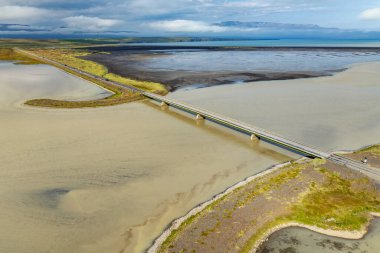 Hopsvatn Gölü 'nden geçen otoyol ve köprü ve Siglufjordur yakınlarındaki Kuzey İzlanda' da nehir deltası.