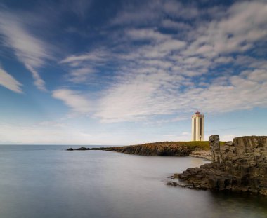 Kuzey İzlanda 'daki Kalfshamarsvik' in bazalt sütunlarının ve deniz fenerinin manzarası