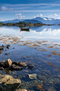 Onarheim yakınlarındaki Hardangerfjord 'un dikey görüntüsü ön tarafta küçük bir kayıkla