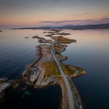 Gün batımında Norveç 'in merkezinde Kristiansund yakınlarındaki Atlantik Okyanus Yolu' nun insansız hava aracı görüntüsü.