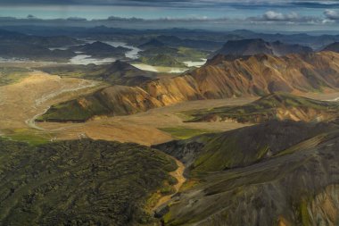 Landmannalaugar yakınlarındaki İzlanda 'nın renkli dağları ve dolambaçlı buzul nehir vadileriyle hava manzarası.