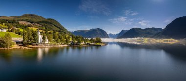 Norveç 'in Vestland ilçesindeki Helgheim kilisesi ve köyünün panorama drone görüntüsü