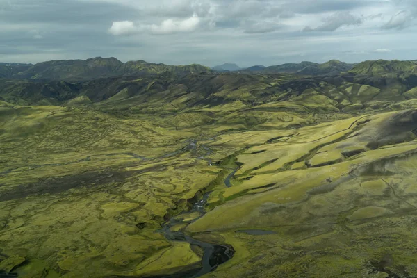 Orta İzlanda 'nın yeşil ve siyah dağlık ovalarından geçen bir buzul nehir sisteminin hava görüntüsü.