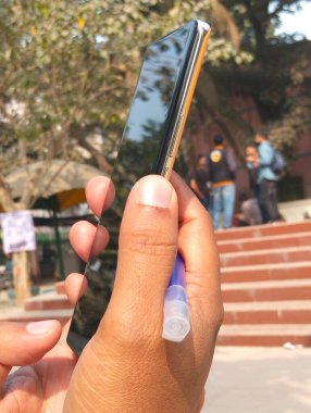 Bulanık Arkaplan ile Açık havada Akıllı Telefonu Tutan Kişi