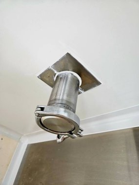 Metal boru aksesuarı beyaz bir tavana kelepçeyle tutturulmuş.