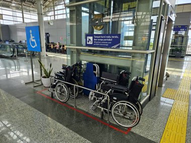 Jakarta, Endonezya - 6 Kasım 2025: Bir toplu taşıma alanındaki asansörün yanına park edilmiş tekerlekli sandalyeler
