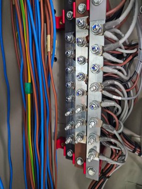 Bir kontrol panelinde elektrik kablolarının ve büstiyerlerin yakın plan görüntüleri.