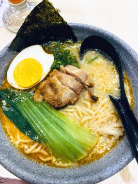 Bir kase lezzetli ramen eriştesinin çeşitli malzemelerle yakın plan çekimi..