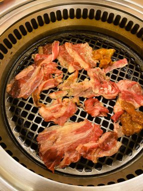 Yakından bakınca ince dilimlenmiş sığır eti ve ızgarada pişmiş et parçaları görünüyor.