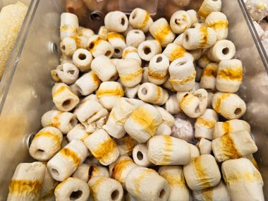 Yakın çekim, geniş beyaz ve sarı çizgili balık köfteleri yığını..