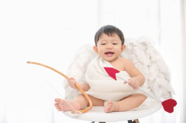 Aşk tanrısı komik, Sevgililer Günü için Eros kostümü ve kanatları olan küçük Asyalı çocuk..