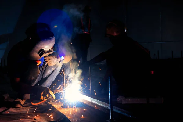 Welder industrial in the factory with smoke from welding job. Industrial worker with steel welding tool.