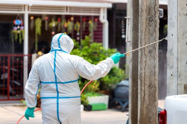 Salgını durdurmak için dezenfektan spreyi, Coronavirüs dezenfeksiyonu. Asyalılar köy parkında dezenfektan yapıyor..
