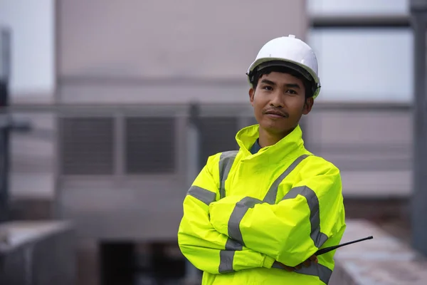 Portrait of Male Industrial Engineer in the Hard Hat and Wear Yellow Safety Jacket while Standing outdoor at the work plant,  Safety Officer working control.