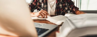 Öğrenmek ve not almak için masada oturan kız öğrenci, covid19 salgını sırasında ev ödevi olarak dizüstü bilgisayar kullanıyor ve internetteki Sosyal Mesafe, Yeni Öğrenci Hayatı. Sancak boyutu.