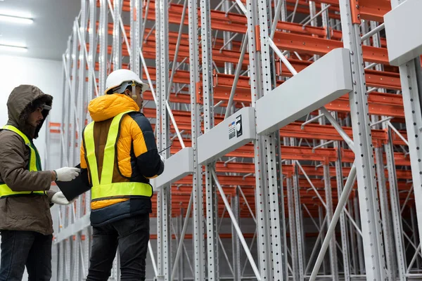 Maintenance technician service in cold warehouse storage, Machinery engineering people checking moving rack system and equipment in warehouse.