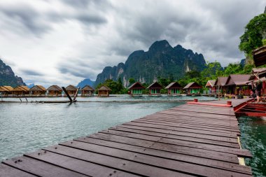 Raft House 'un güzel manzarası göl nehrinde güzel su yansıması olan ev sahipliği yapıyor. Tayland' ın Surat Thani Eyaleti 'ndeki Khao Sok Ulusal Parkı' ndaki Ratchaprapha Barajı..