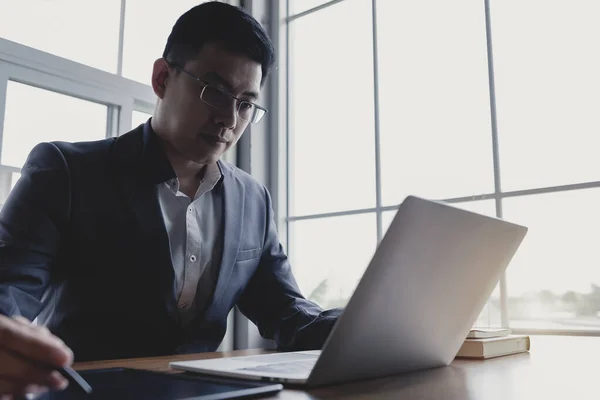 Asian Business people wearing suite working on desk office with laptop and tablet.