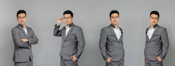 Portrait of Asian businessman happy smiling in grey confident suit. Isolated on grey background in studio. Freestyle pose in the banner.