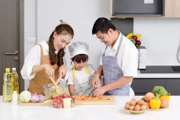 亚洲父母正在教女儿们如何轻松地在家做饭沙拉食品 一家人都喜欢在现代家里的厨房里一起做饭 注重中心女童 — 图库照片