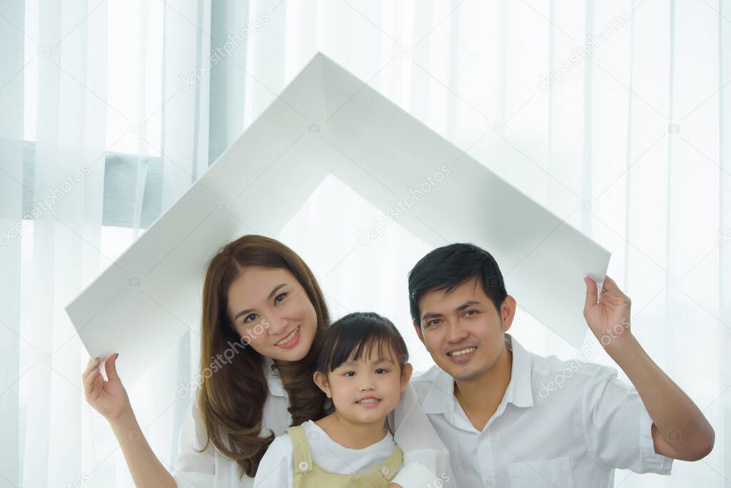 Asian young family happy to playing housing, Mother with Father and Children at living room in new home. New life family, Stable housing concept. Soft focus on Children center.