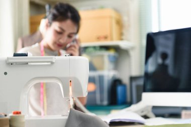 Moda tasarımcısının masasında dikiş makinesi, tasarım stüdyosu, giysi tasarımı serbest meslek..