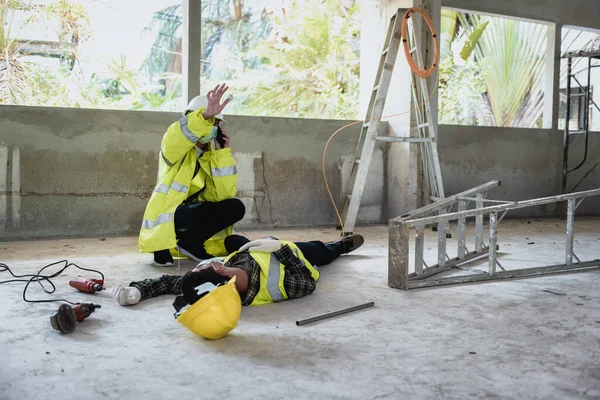 Work accidents of worker in workplace at construction site area and Unconscious with colleague motion and call to the safety officer for rescue and Life-saving. Selection focus on an Injured person.