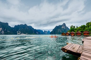 Asya Gölü 'nde Red Canoe ve Tayland' ın Surat Thani Eyaleti 'nde arka planda dağları olan adaların arasında kalan Raft House Home' la keyifli bir gezi..