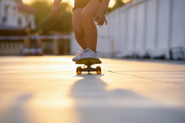 スケートボードをしているクローズアップの女の子の子供は 日没や夕方に家の近くの屋外で練習のバランスをとりながら — ストック写真