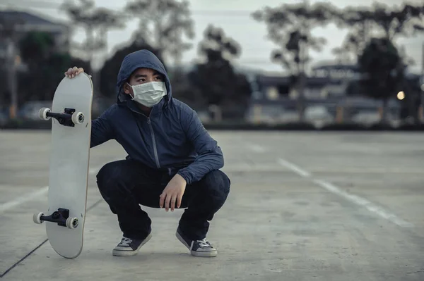 Trött Asiatiska Kid Bär Skyddande Ansiktsmasker Sitter Utomhus Med Skateboard — Stockfoto